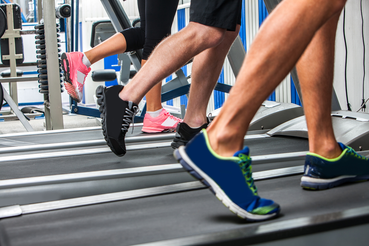 group of legs wearing sneakers running on treadmill